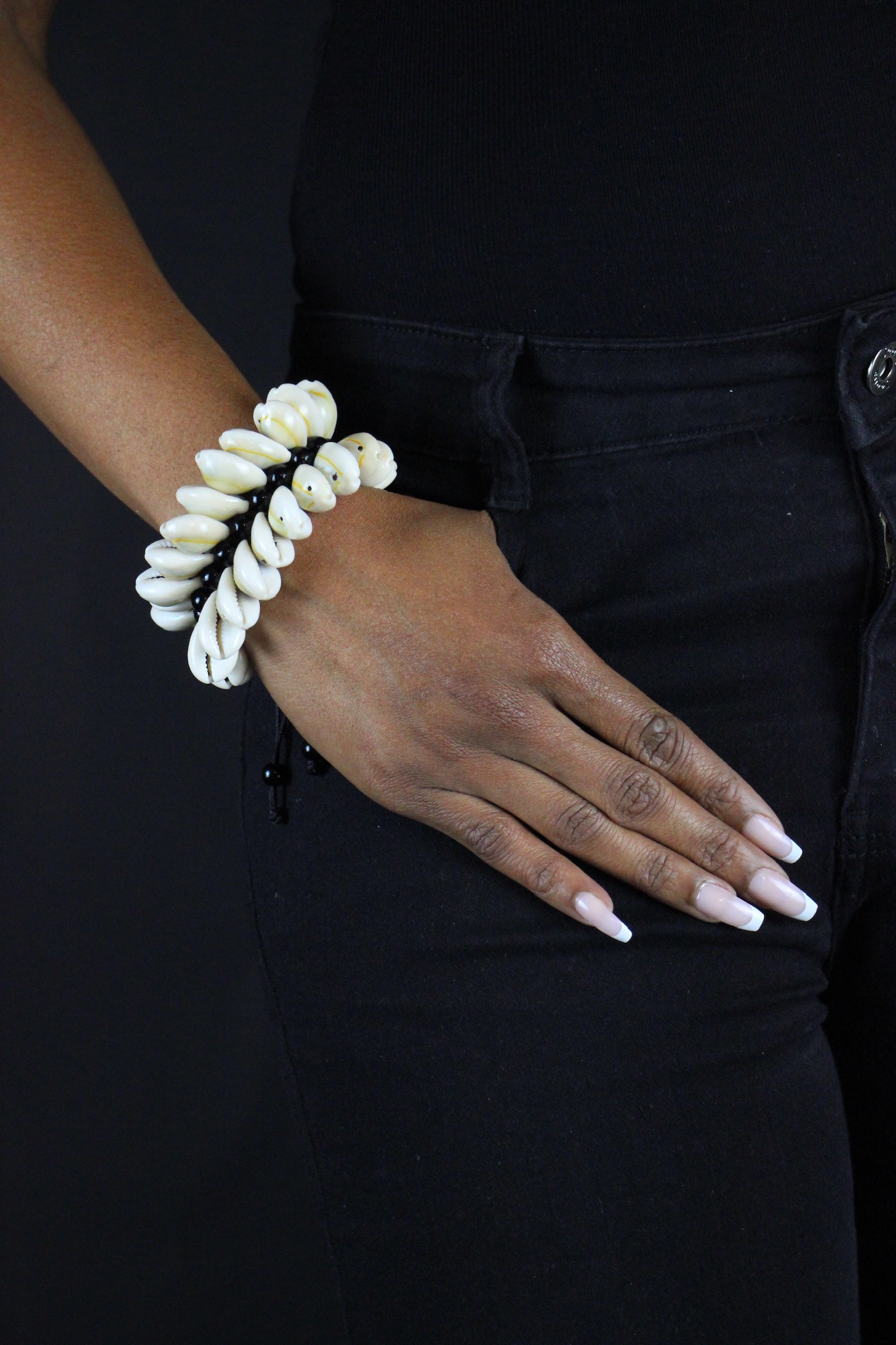 Bracelet en perles noires et guirlande de cauris